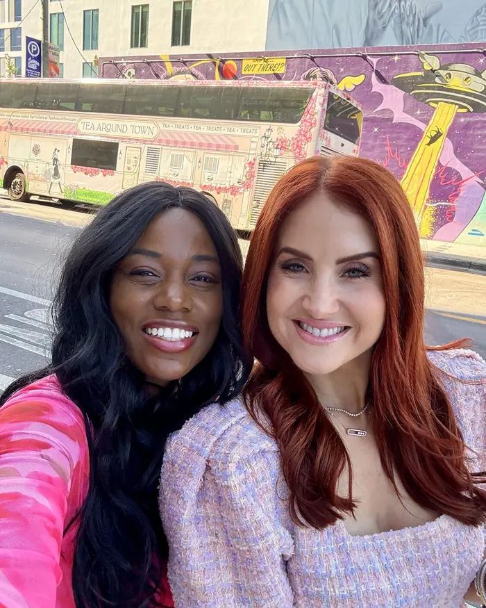 Sharonda and a friend taking a selfie in front of a colorful mural