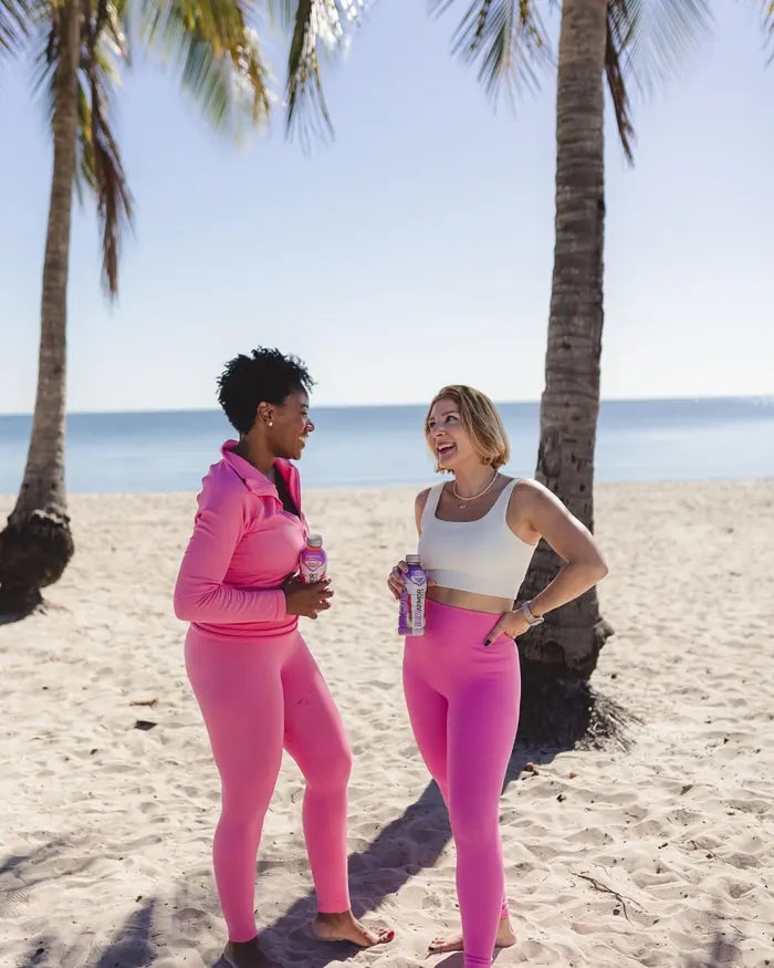 Sharonda and a friend in pink activewear on the beach