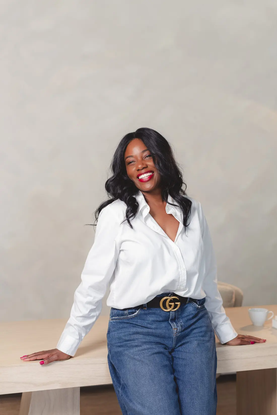 Sharonda smiling in a crisp white shirt and denim